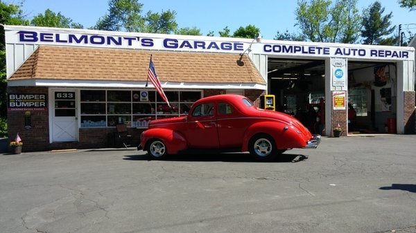 The Belmont's Garage storefront with a classic red coupe parked out front